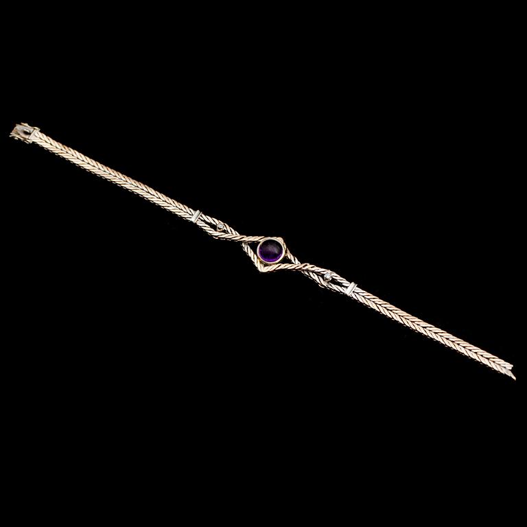 ARMBAND, 18 k vitguld, med cabochonslipad ametist samt 2 små briljanter. Total vikt ca 18 g.