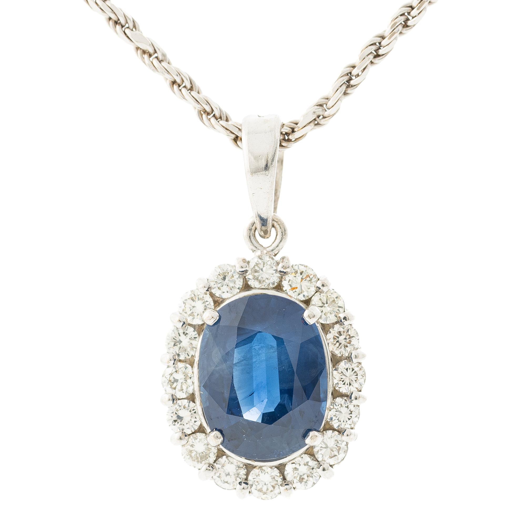 Pendant in 18K white gold with a faceted sapphire and round brilliant-cut diamonds.