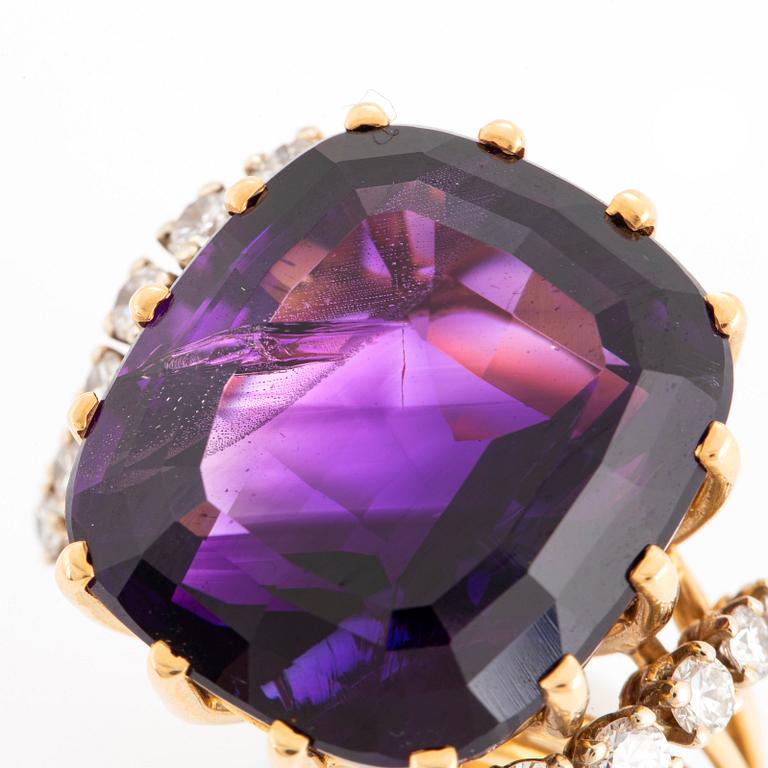 An 18K gold ring set with a faceted amethyst and round brilliant-cut diamonds.