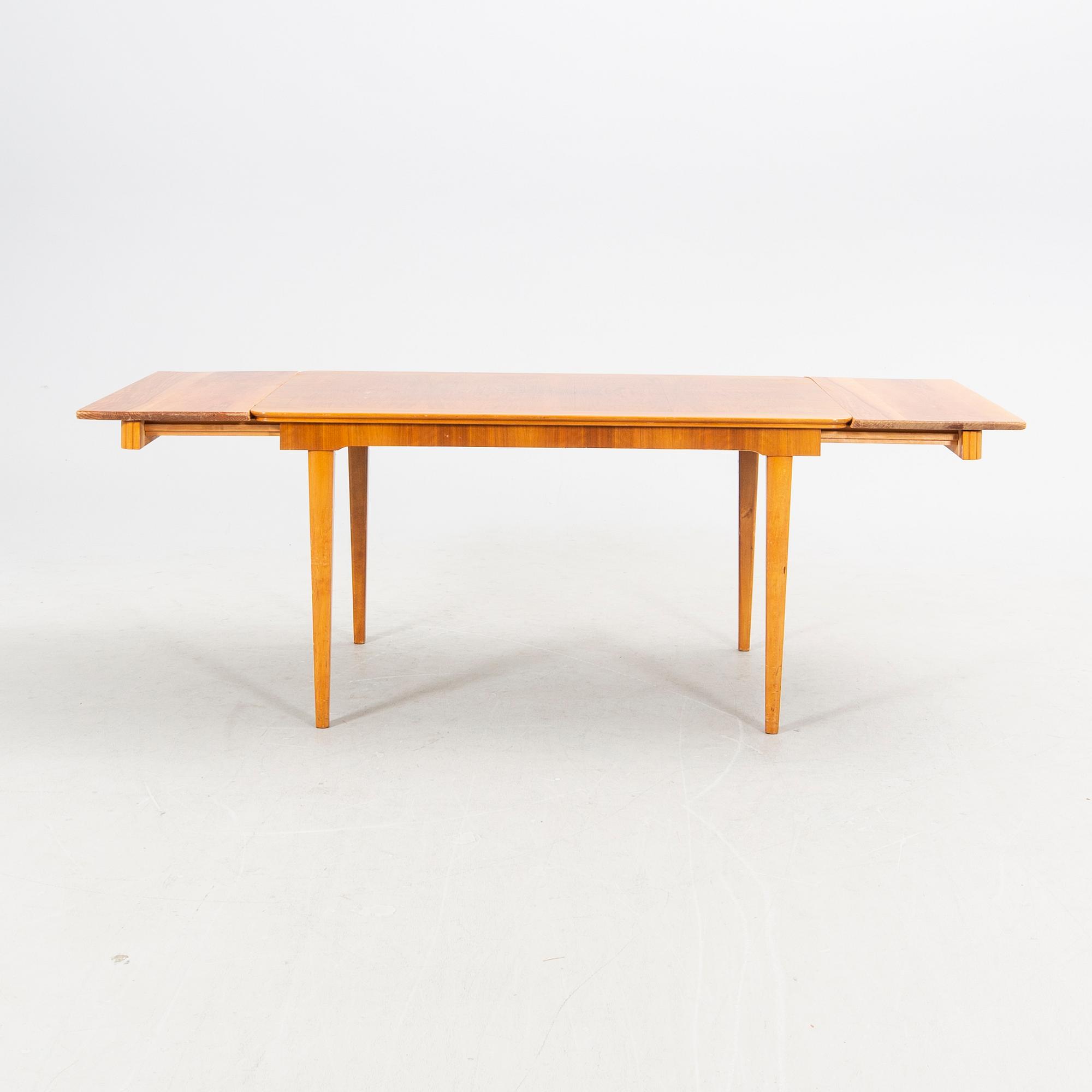 A 1940s mahogany and walnut dining table.