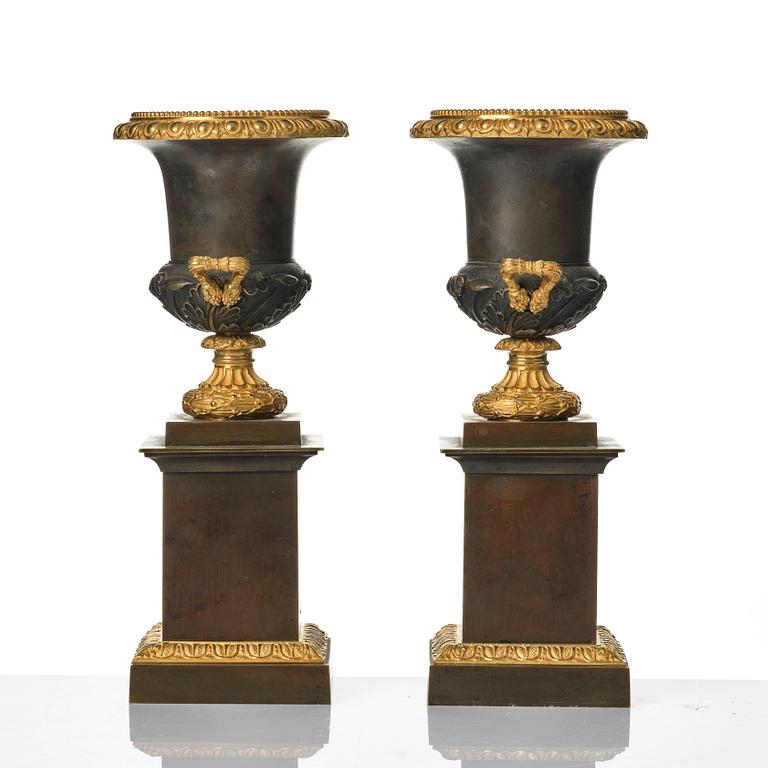 A pair of French Louis Philippe gilt and patinated bronze urns, first part 19th century.