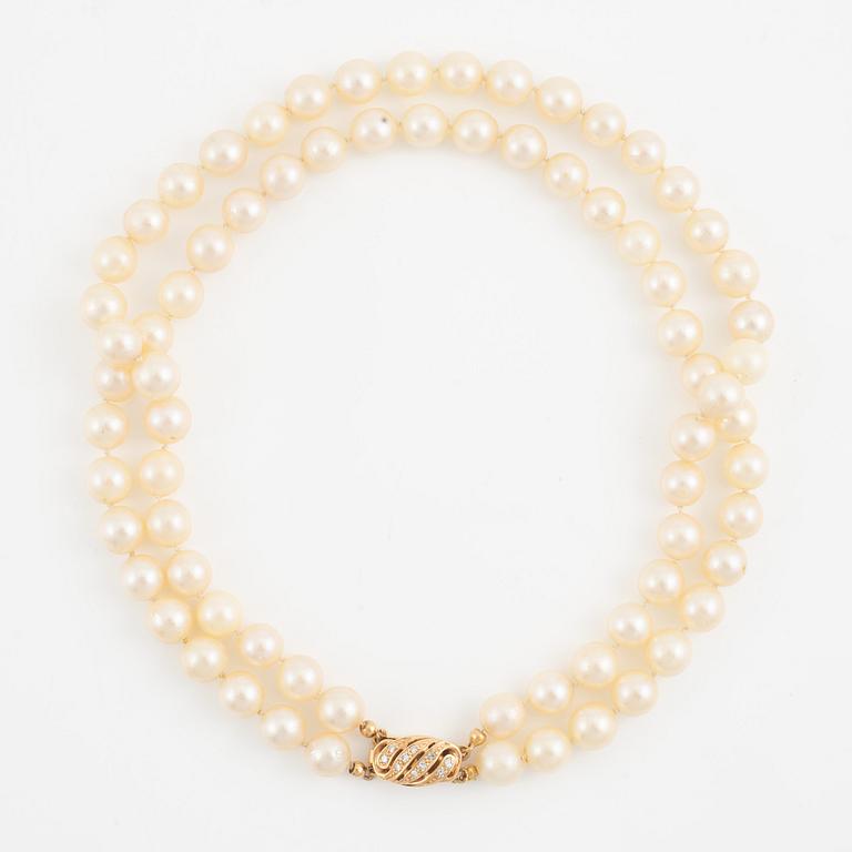 Necklace of two strands of cultured pearls, clasp with 18K gold lock set with eight-cut diamonds.