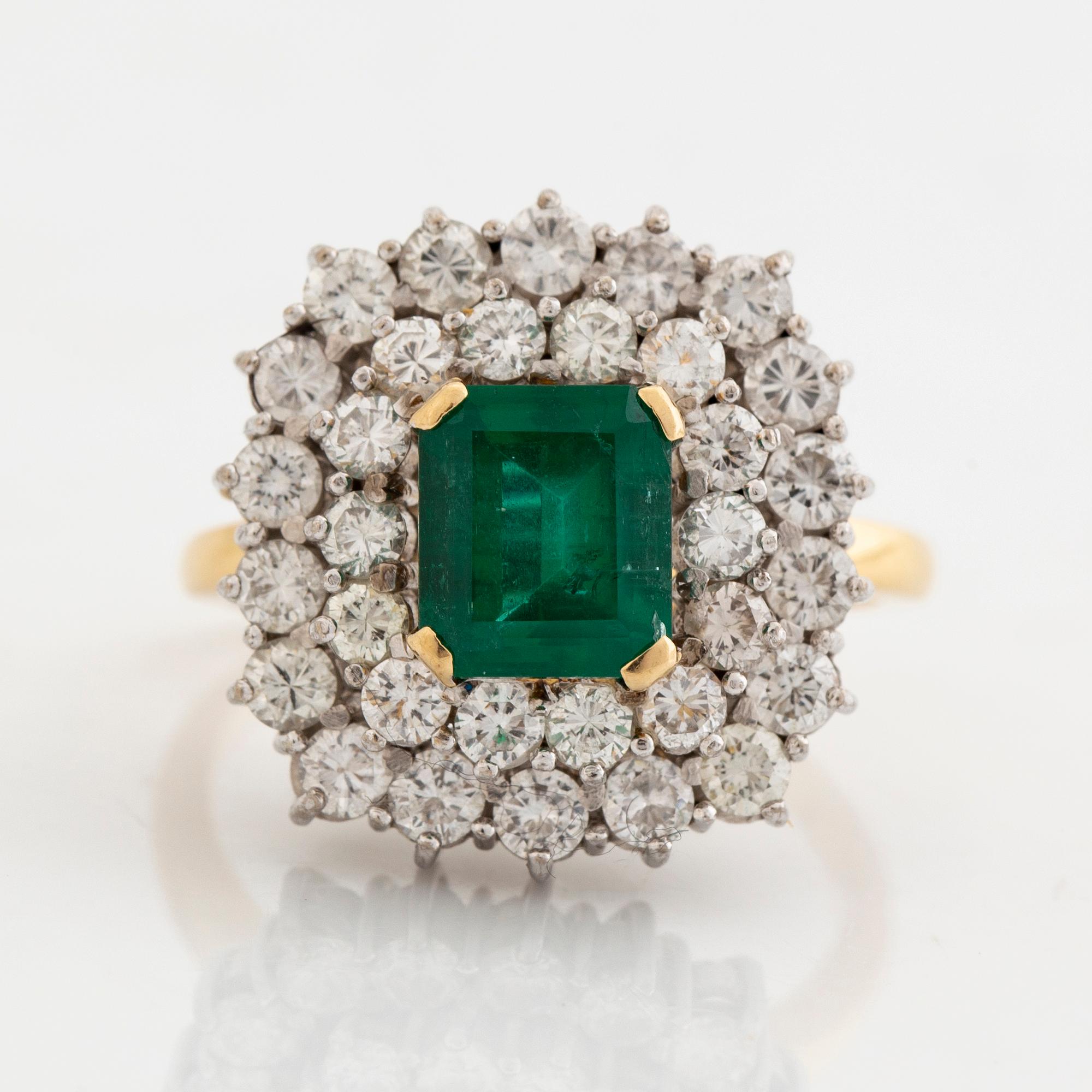 Ring, 18K guld, smaragdslipad smaragd ca 2 ct, med 32 briljantslipade diamanter totalt ca 2 ct.