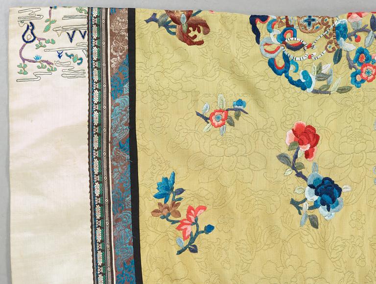 A ROBE, pattern woven and embroidered silk. Height 119,5 cm. China late Qing dynasty.