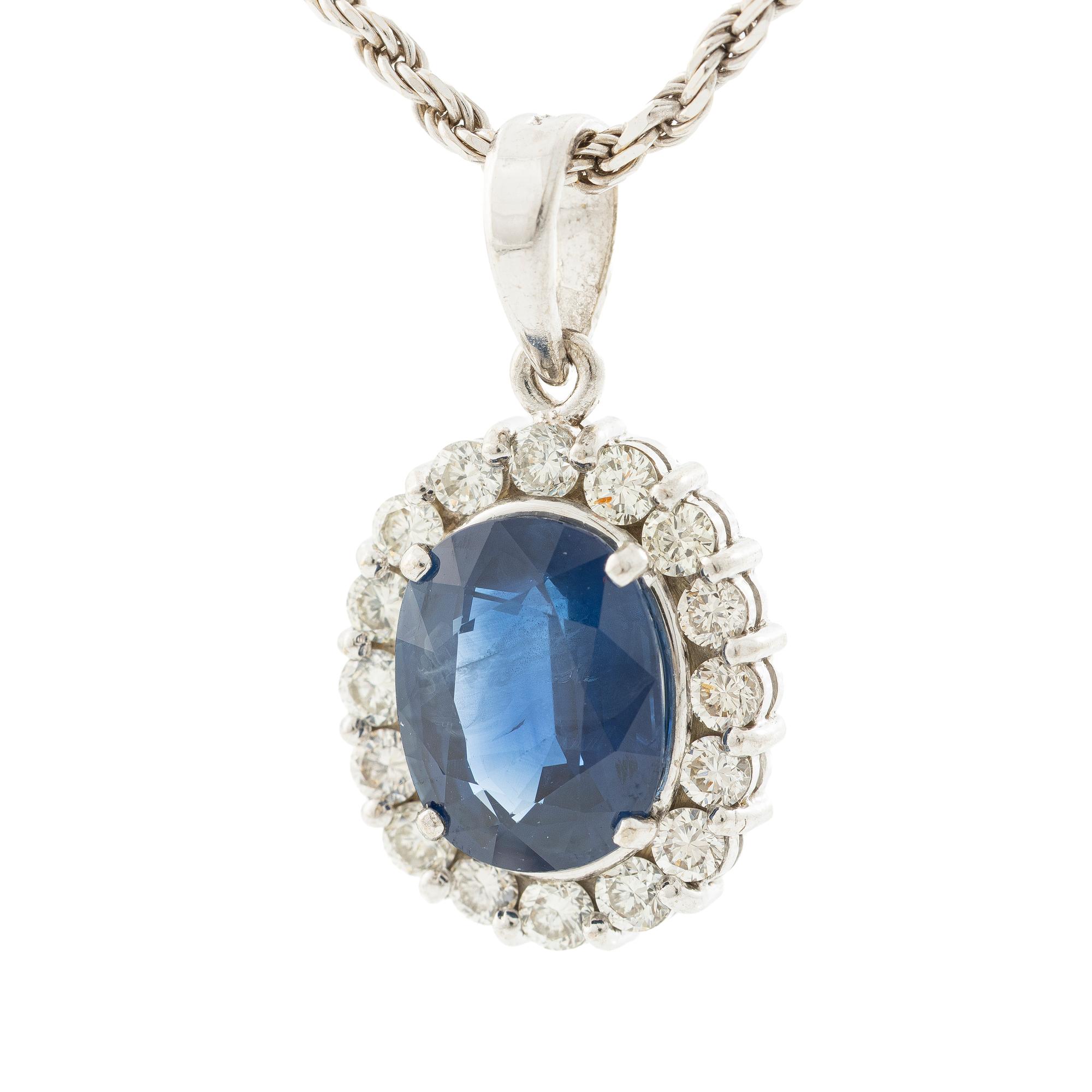 Pendant in 18K white gold with a faceted sapphire and round brilliant-cut diamonds.