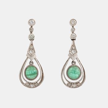 Earrings with cabochon-cut emeralds and brilliant-cut diamonds.