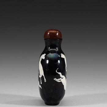 An enamelled porcelain snuff bottle with stopper, Qing dynasty (1644-1912).