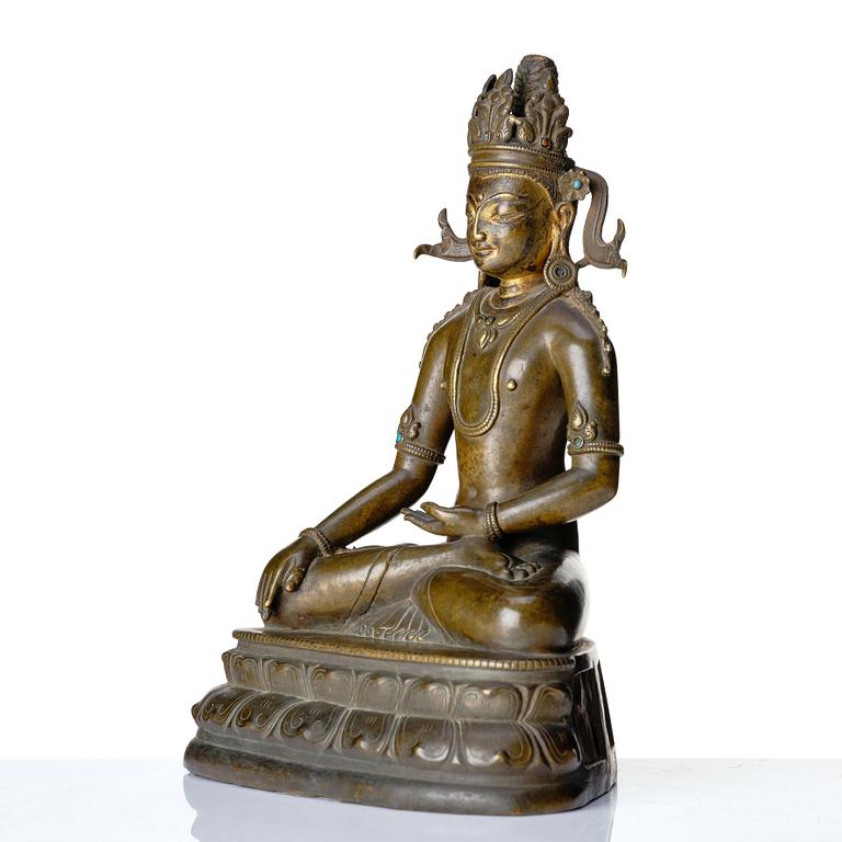 A bronze figure of a crowned buddha, Tibet, 14th Century.