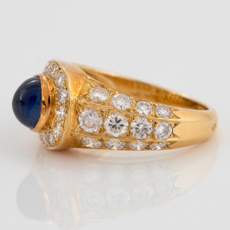 An 18K gold Wempe ring set with sapphires and round brilliant-cut diamonds.