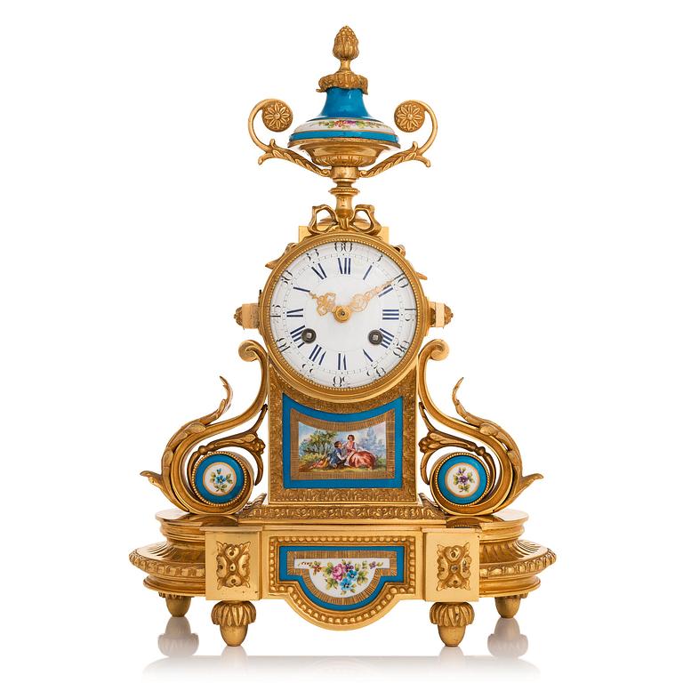 A mid-19th-century French gilt-brass mantel clock with a pair of candelabra by Dussault.