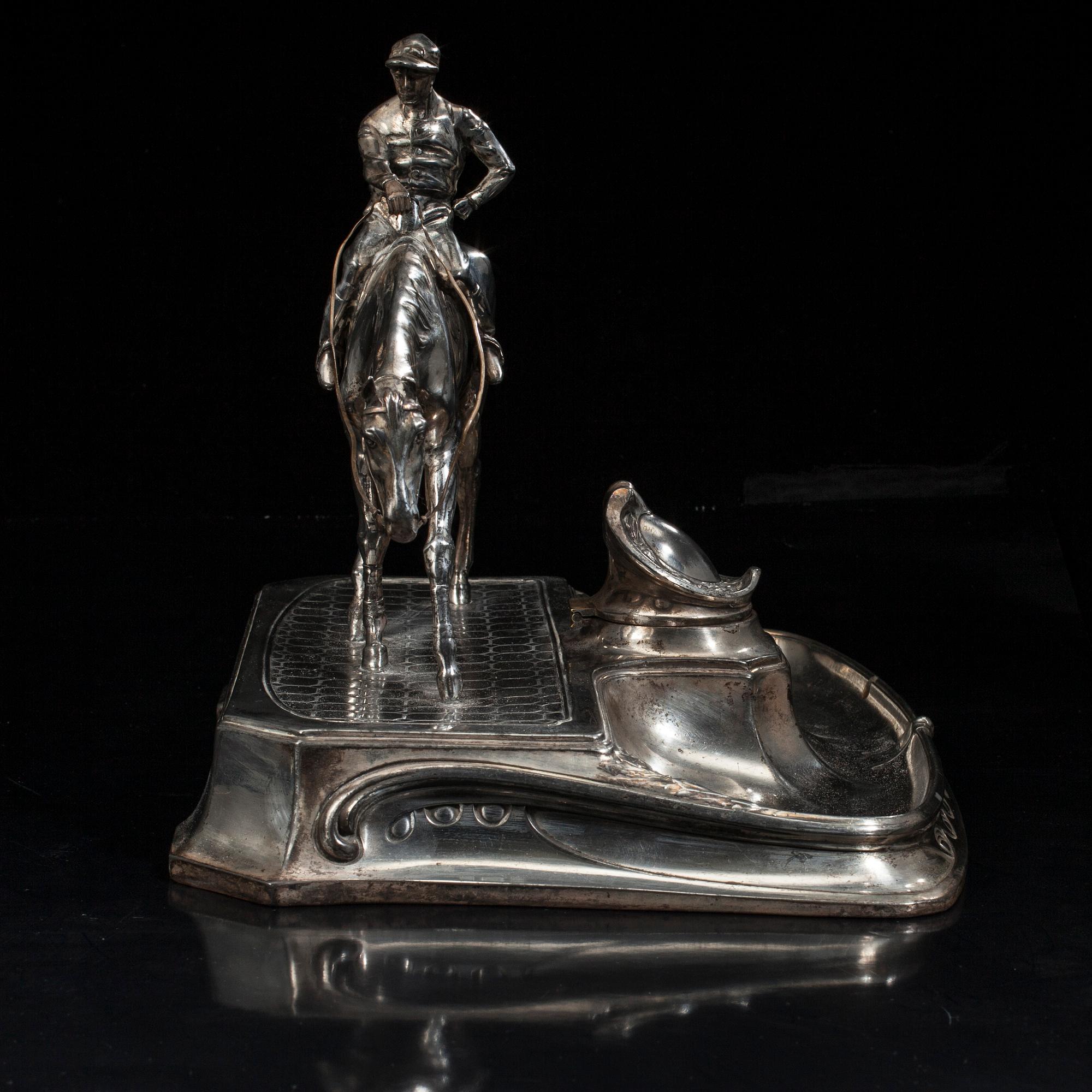 SKRIVSTÄLL med jockeyn Fred Archer till häst. Vitmetall. Sannolikt England, sent 1800-tal.