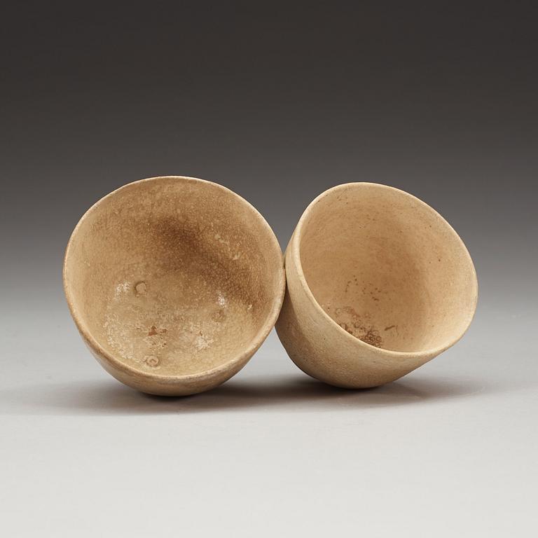 Two white-glazed pottery wine cups, presumably Tang dynasty (618-907).