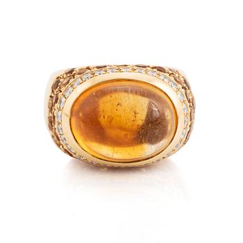 398. An 18K gold ring set with a cabochon-cut citrine and round brilliant-cut diamonds och citrines.