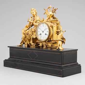 A late 19th century table clock and a pair of candlesticks.
