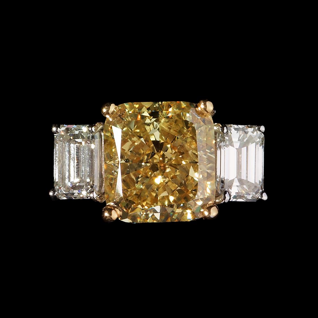RING, radiant cut fancy gul diamant, 3.84 ct samt på vardera sida smaragdslipade diamanter, tot. 1 ct.