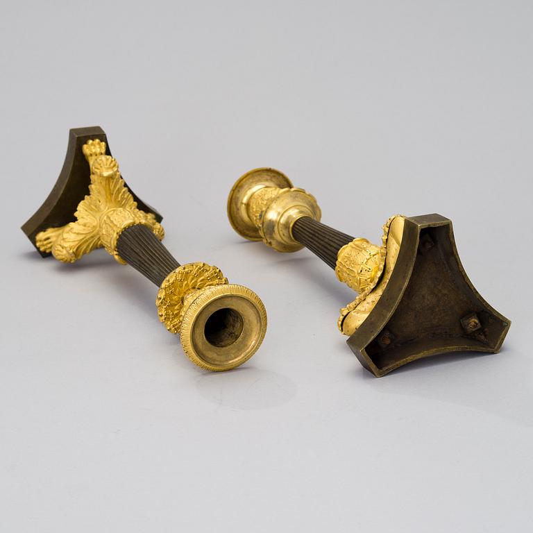 A pair of bronze late empire candlesticks from France of the first half of the 19th century.