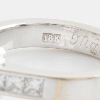 An 18K white gold ring set with an emerald-cut diamond.