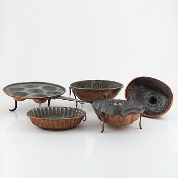 Four cake moulds, and a funnel, copper, 18th and 19th Century.