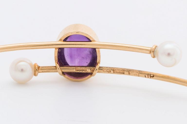 ARMRING 18K guld med 1 cabochon-slipad ametist ca 11 x 7 mm samt 2 odlade pärlor ca 5 mm, 1962.