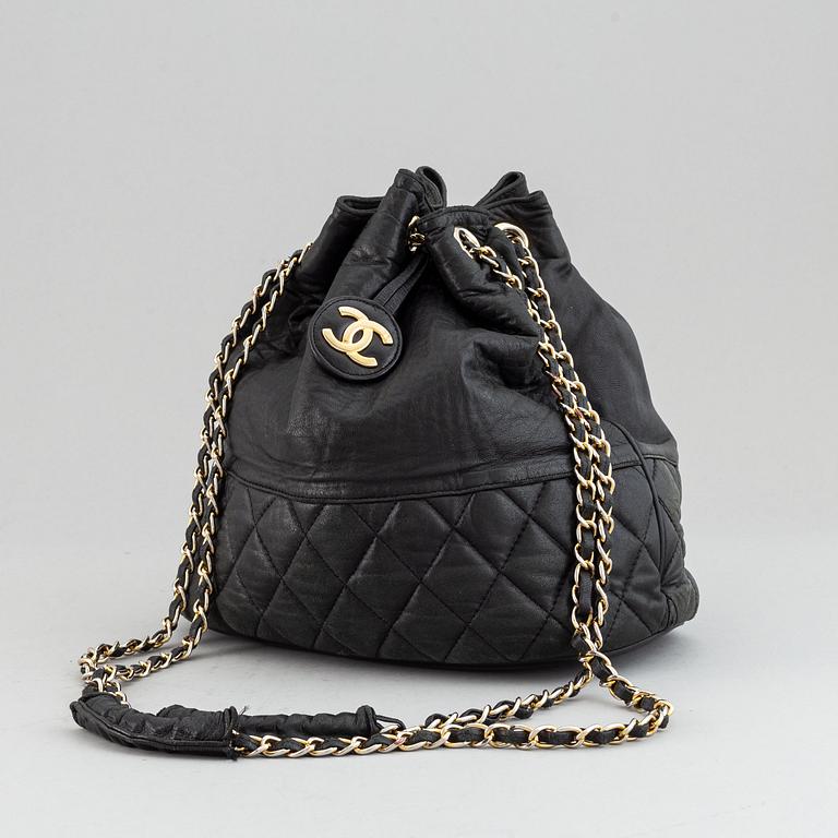 Chanel, a black leather drawstring bag.