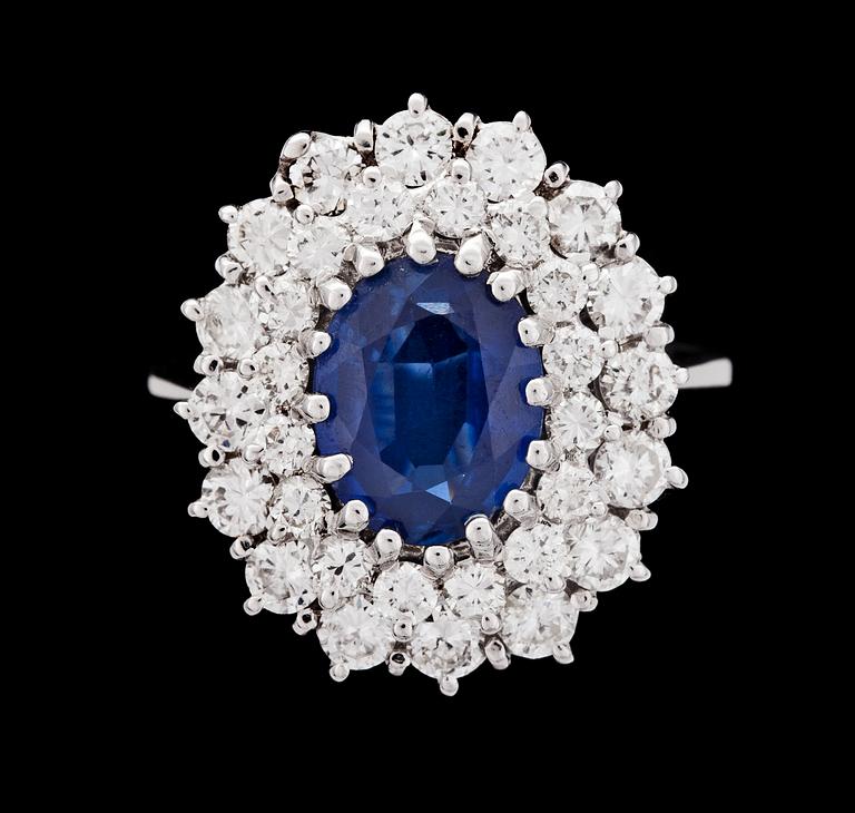 RING, oval fasettslipad blå safir, ca 2 ct med briljantslipade diamanter, ca 2 ct.