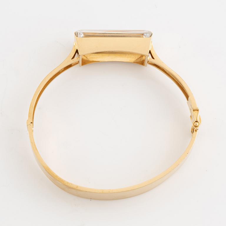 An 18K gold bangle set with synthetic spinel.