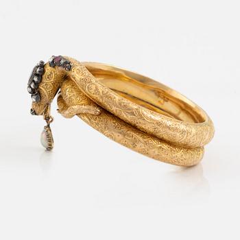 A Victorian snake bracelet in 14K gold with rose-cut diamonds, red stones and a half pearl.