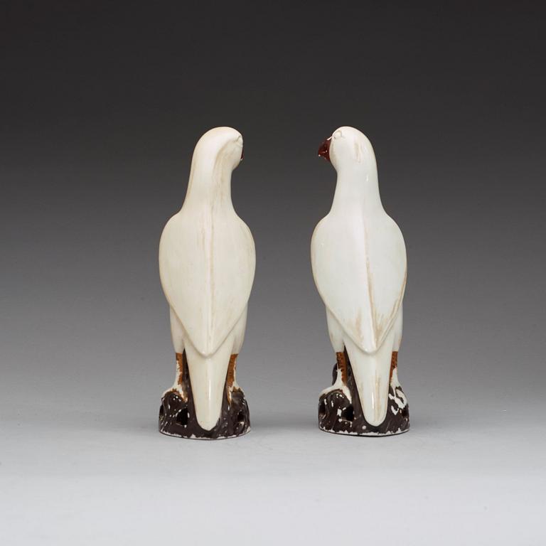 A pair of white andred glazed figures of parrots, late Qing dynasty.