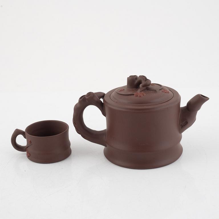 A Chinese yixing ware teapot with four cups, 20th century.