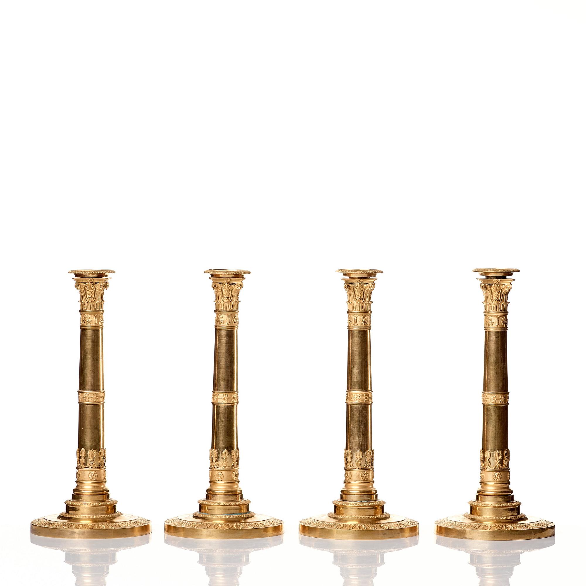A set of four Empire presumably Russian candlesticks in gilded bronze.