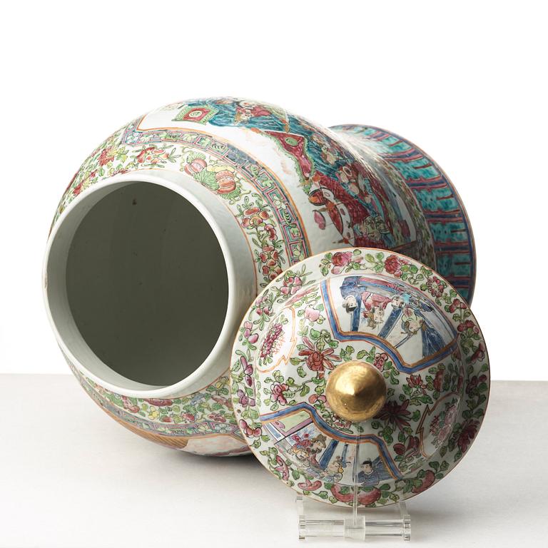 A Canton famille rose jar with cover on a tall wooden stand, Qing dynasty, late 19th Century.