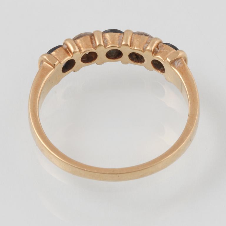 RING, 18K guld med 2 briljantslipade diamanter samt 3 fasettslipade blå safirer, kattfotstämplad. Vikt 2,9 gram.
