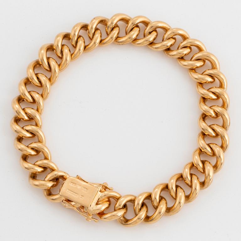 An 18K gold curb link bracelet.