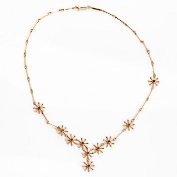 Kirsti Doukas, kaulakoru, "Pohjantähti", 18K kultaa ja granaatteja, Kalevala Koru, Helsinki 2006. Numeroitu 86/200.