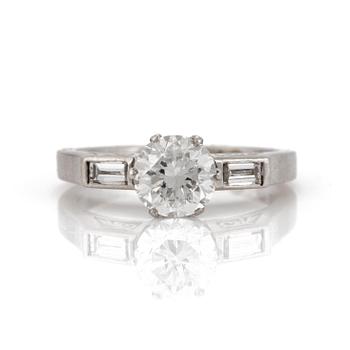 A ring set with a round, brilliant-cut diamond and two baguette-cut diamonds to the shoulders.