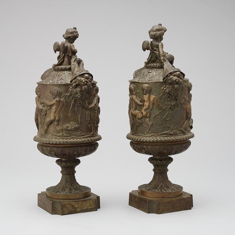 A pair of 19th century bronze urns in the manner of Clodion.