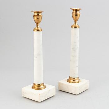 A pair of late Gustavian brass and cararra marble candle holders, around the year 1800.