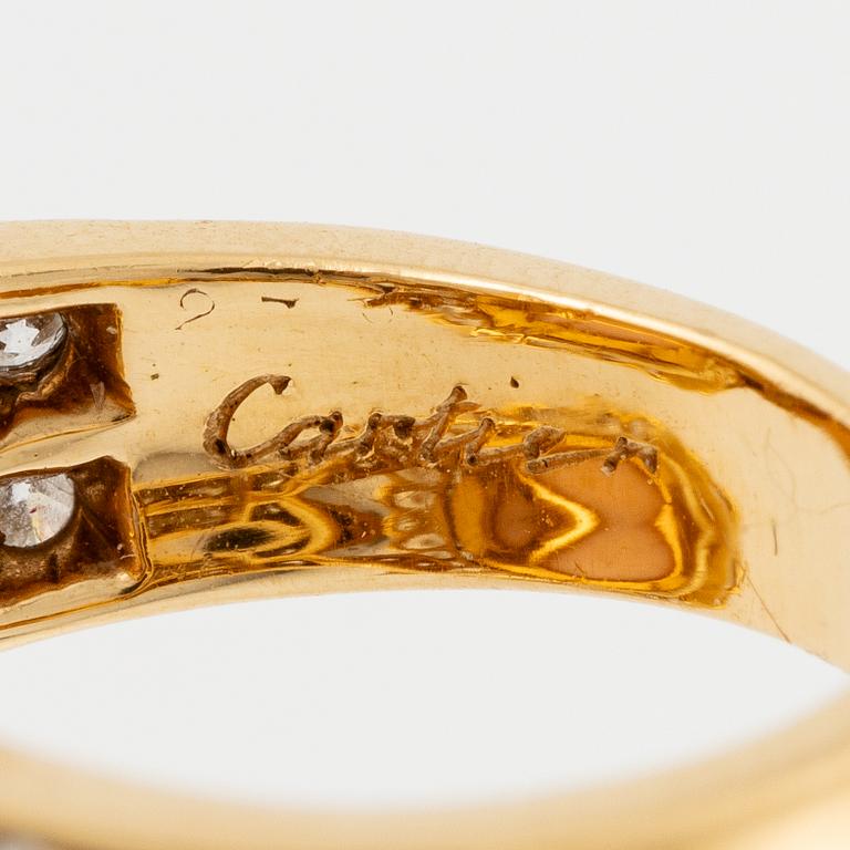 An 18K gold and coral Cartier ring set with round brilliant-cut diamonds.