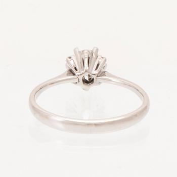 An 18K white gold ring set with a round brilliant cut diamond and single cut diamonds.
