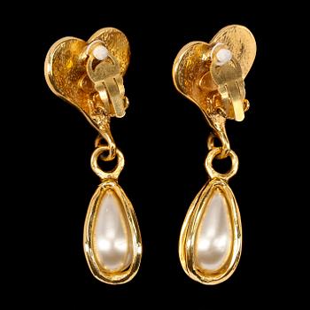 A pair of golden earclips with a decorative pearl by Chanel.