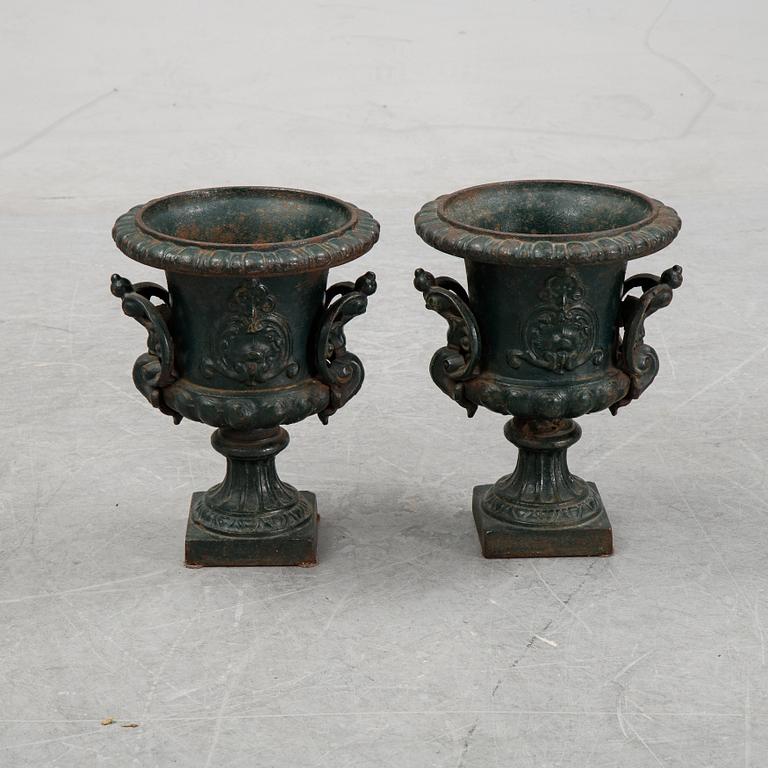 A pair of cast iron garden urns.