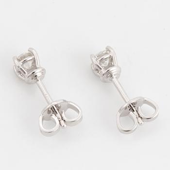 A pair of brilliant cut diamond earrings.