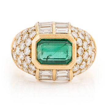 An 18K gold ring with an emerald-cut emerald and baguette and round brilliant-cut diamonds.