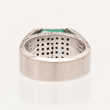 A 9K white gold ring with an emerald and brilliant cut diamonds.