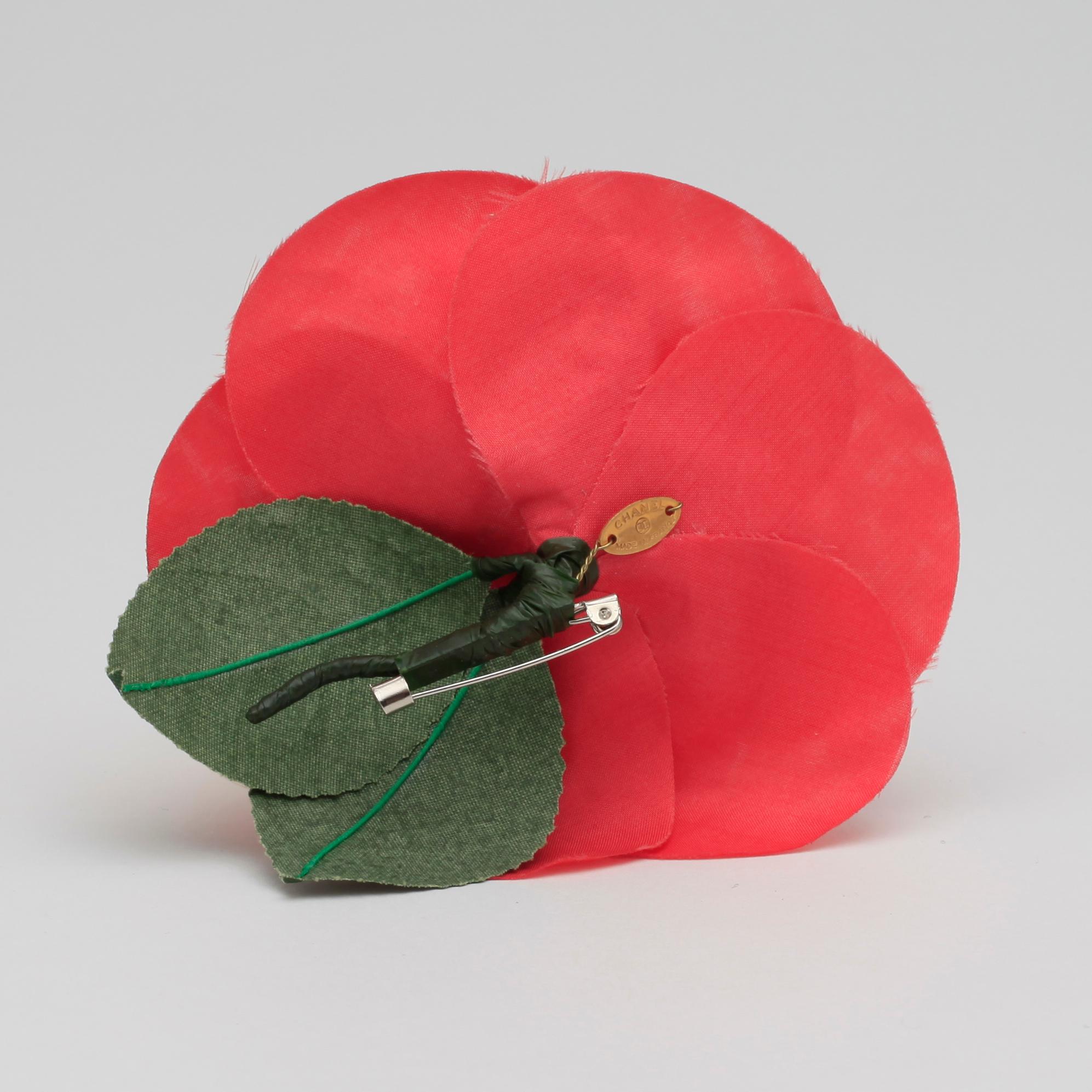 CHANEL, a red brooch.