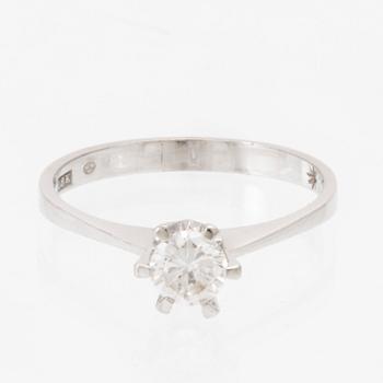 An 18K white gold solitaire ring set with a round brilliant-cut diamond.