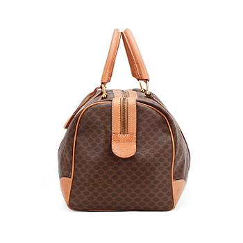 CÉLINE, a brown coated monogram canvas weekend bag.