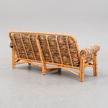 A set of two garden sofas, an armchair and a glass table, later part of the 20th Century.