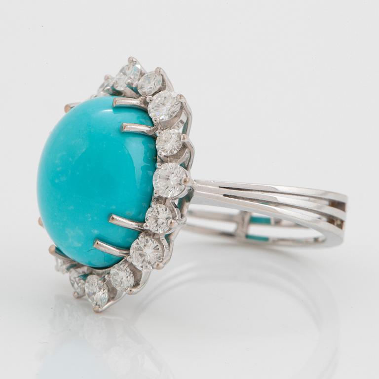 An 18K white gold ring set with a cabochon-cut turquoise and round brilliant-cut diamonds.