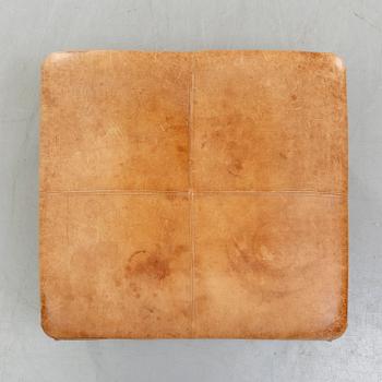 A leather ottoman/coffee table alter part of the 20th century.